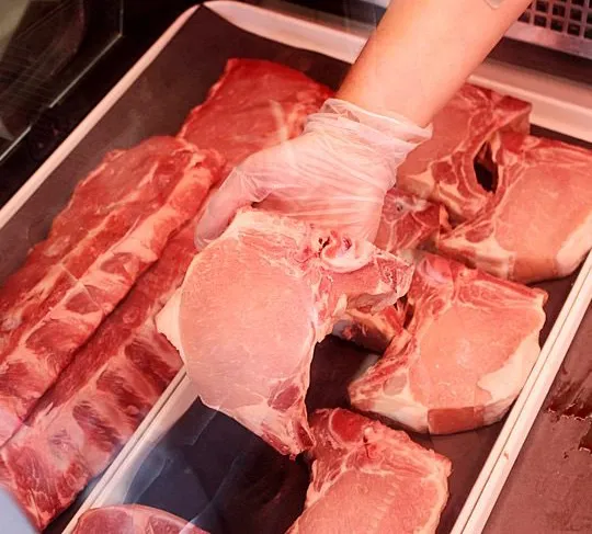 pork-trays-in-counter Top view fresh meat slices raw meat with greens and tomatoes